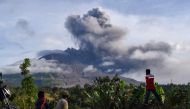 Villagers watch the eruption of Mount Sinabung as seen from Karo, North Sumatra on August 13, 2020. Indonesia's Mount Sinabung erupted again on August 13 with a string of blasts that sent plumes of ash two kilometres (1.2 miles) into sky, triggering a fli