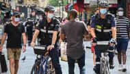 Paris municipal police officers wearing face masks ask people to put on their masks in Montorgueil street in Paris, on August 15, 2020. (AFP / BERTRAND GUAY)