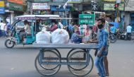A man and his son push a cart where a young boy sits in Siliguri on August 19, 2020, as a state-imposed lockdown will be held on August 20 and 21 against the surge in COVID-19 coronavirus cases. / AFP / DIPTENDU DUTTA