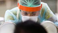 A medical personnel performs a nose swab test on a local resident of a community in Bangkok, amid the coronavirus disease (COVID-19) outbreak in Thailand, April 28, 2020. REUTERS/Athit Perawongmetha/File Photo