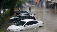 People wade through a flooded street with submerged vehicles during the monsoon rain, as the outbreak of the coronavirus disease (COVID-19) continues, in Karachi, Pakistan August 25, 2020. REUTERS/Akhtar Soomro
