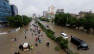 People wade through the flooded road with submerged vehicles during monsoon rain, as the outbreak of the coronavirus disease (COVID-19) continues, in Karachi, Pakistan August 27, 2020. REUTERS/Akhtar Soomro
