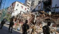 Lebanese soldiers walk past a partially destroyed traditional building which was afffected by the Beirut port blast, in the Gemmayzeh neighbourhood, on August 26, 2020. AFP / JOSEPH EID