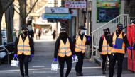 Cleaners walk down a street as the city operates under lockdown in response to an outbreak of the coronavirus disease (COVID-19) in Melbourne, Australia, September 3, 2020. AAP Image/Erik Anderson via REUTERS