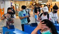 People wearing face masks amidst concerns over the spread of COVID-19 novel coronavirus enter a commuter train station in Bangkok on September 2, 2020. Thailand on September 2 registered its 100th consecutive day without a local infection of the COVID-19 