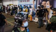 Police question a group of people as they patrol the area after protesters called for a rally in Hong Kong on September 6, 2020 to protest against the government's decision to postpone the legislative council election due to the COVID-19 coronavirus, and 
