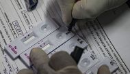 A health worker marks a number on a rapid antigen test kit during a Covid-19 coronavirus screening for frontline civic staff in Mumbai on September 10, 2020. / AFP / INDRANIL MUKHERJEE
