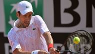 Serbia's Novak Djokovic plays a backhand to Italy's Salvatore Caruso on day three of the Men's Italian Open at Foro Italico on September 16, 2020 in Rome, Italy. / AFP / POOL / Riccardo Antimiani