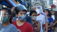 In this photo taken on September 19, 2020, people wearing face shields queue up at a public market in Manila. Many face the new normal in the Philippines, where it is now compulsory to wear both face masks and plastic shields in indoor public spaces and o