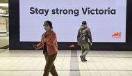 People pass a sign at Melbourne's Flinders Street station on September 17, 2020. Australia's unemployment rate on September 17 fell slightly to 6.8 percent in August, spurring hopes that the worst of a coronavirus-fuelled recession may have passed. / AFP 