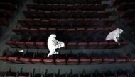 Workers wearing personal protective equipment (PPE) sanitize and clean the seats of Star theatre ahead of its reopening, amidst the outbreak of the coronavirus disease (COVID-19), in Kolkata, India, September 29, 2020. REUTERS/Rupak De Chowdhuri
