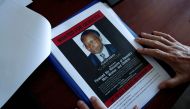 FILE PHOTO: Eric Emeraux, head of the Gendarmerie's Central Office for Combating Crimes Against Humanity, Genocides and War Crimes (OCLCH), displays documents with a wanted poster depicting a photograph of Felicien Kabuga during an interview with Reuters 
