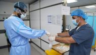A doctor, wearing protective gear, handles a test for the coronavirus disease (COVID-19), at Rafik Hariri University Hospital, in Beirut, Lebanon October 1, 2020. Picture taken October 1, 2020. REUTERS/Issam Abdallah