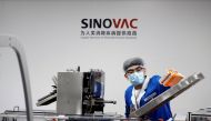 FILE PHOTO: A man works in the packaging facility of Chinese vaccine maker Sinovac Biotech, developing an experimental coronavirus disease (COVID-19) vaccine, during a government-organized media tour in Beijing, China, September 24, 2020. REUTERS/Thomas P