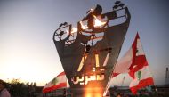 Lebanese protesters stand beneath the 