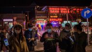 People wearing face masks as a preventive measure against the Covid-19 show a QR code 