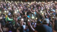 Pro-democracy protesters hold up their mobile phones with lights during an anti-government rally at Asok in Bangkok on October 18, 2020, as they continue for the fourth consecutive day to defy an emergency decree banning gatherings. / AFP / Mladen ANTONOV