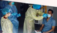 A migrant worker undergoes a nose swab test as medical workers look on at a dormitory amid the coronavirus disease (COVID-19) outbreak in Singapore, April 28, 2020. REUTERS/Edgar Su/File Photo