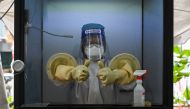 TOPSHOT - A health worker gives a thumbs-up as she stands in a non-contact chamber called the 