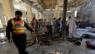 Rescue workers collect remains at the site of a blast in a religious school in Peshawar on October 27, 2020. AFP / Abdul Majeed 