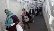 Mask-clad Iranians walk along an overpass on their way to shop in Tajrish square in the capital Tehran on November 1, 2020, amid the novel coronavirus pandemic crisis. AFP / ATTA KENARE