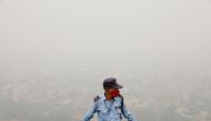A security guard stands on top of a building amidst heavy smog in New Delhi, India, November 4, 2020. REUTERS/Adnan Abidi

