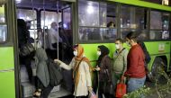 Iranian People wearing protective masks as they board a bus, amid the outbreak of the coronavirus disease (COVID-19), in Tehran, Iran November 11, 2020. Picture taken November 11, 2020. Majid Asgaripour/WANA