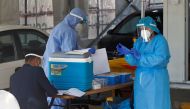 Healthcare workers prepare to take nose samples to check for the coronavirus disease (COVID-19) at a drive-thru testing station in Amman, Jordan, November 17, 2020. REUTERS/Muhammad Hamed