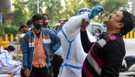 A medical worker wearing protective gear collects a nasal swab sample from a man for a Rapid Antigen Test (RAT) for the Covid-19 coronavirus as Noida authorities started conducting random coronavirus testing on commuters arriving from Delhi at Delhi-Uttar