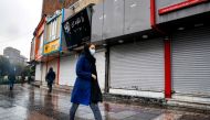 Pedestrians, mask-clad due to the Covid-19 coronavirus pandemic, walk past closed shops along a street in Iran's capital Tehran on November 21, 2020, as the Iranian government announced new pandemic-countering measures. AFP / STR