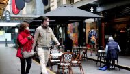 People walk past a cafe after the coronavirus disease (COVID-19) restrictions were eased for the state of Victoria, in Melbourne, Australia, October 28, 2020. REUTERS/Sandra Sanders