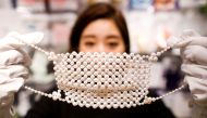 An employee of Cox Co, the operation company of the face-mask speciality shop Mask.com, shows off a luxury face mask made with about 330 pearls which is sellig for one million yen ($9,640), at the shop, amid the coronavirus disease (COVID-19) outbreak, in