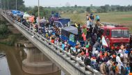 Farmers gather on a bridge as police block a road during a march to India's capital New Delhi to protest against the central government's recent agricultural reforms, on the outskirts of Ambala on November 26, 2020. AFP 