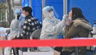 Medical staff members wearing protective gear take samples for the Covid-19 test from visitors at a testing station in SEOUL on November 27, 2020. / AFP / Jung Yeon-je
