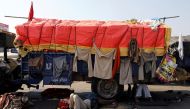 Farmers rest under a truck at a site of a protest against the newly passed farm bills at Singhu border near Delhi, India, November 29, 2020. REUTERS/Anushree Fadnavis