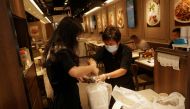 A staff member wearing a face mask following the coronavirus disease (COVID-19) outbreak hands takeaway food to a customer at a restaurant in Hong Kong, China July 20, 2020. Reuters/Lam Yik/File Photo