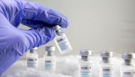 Woman holds a vial labelled 