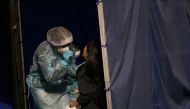 A health worker collects a swab sample from a woman at a makeshift testing centre on a soccer field following the coronavirus disease (COVID-19) outbreak in Hong Kong, China December 8, 2020. REUTERS/Lam Yik