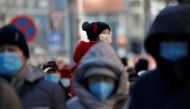 People wearing masks walk in a street in Beijing?s central business district (CBD) during morning rush hour, following the coronavirus disease (COVID-19) outbreak, in China December 8, 2020. REUTERS/Tingshu Wang/File Photo