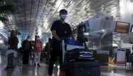 Passengers wearing protective face masks walk at the Soekarno-Hatta Airport amid the coronavirus disease (COVID-19) pandemic, in Tangerang, on the outskirts of Jakarta, Indonesia December 23, 2020. Antara Foto/Muhammad Iqbal/via Reuters. 