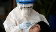 A healthcare worker takes a nasal swab sample of a migrant worker for a COVID-19 test at a migrant community, amid the coronavirus disease (COVID-19) outbreak, in Samut Sakhon province, in Thailand, December 20, 2020. REUTERS/Athit Perawongmetha/File Phot
