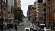 Pedestrian crosses a road usually packed with heavy traffic in the central business district in Sydney on December 30, 2020, as authorities work to suppress a growing cluster of Covid-19 coronavirus cases in Australia's most populous city. / AFP / Saeed K
