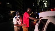 A Johannesburg Metro Police Department (JMPD) officer frisks a driver during a roadblock after curfew, to help curb the spread of COVID-19, in Johannesburg on December 29, 2020. AFP / Wikus de Wet