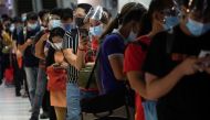 Passengers wearing face masks and face shields for protection against the coronavirus disease (COVID-19) queue for bus rides going to provinces amid the holiday season, at the Paranaque Integrated Terminal Exchange, in Paranaque City, Metro Manila, Philip