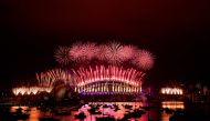 New Year's Eve fireworks erupt over Sydney's iconic Harbour Bridge and Opera House (L) during the fireworks show on January 1, 2021. / AFP / SAEED KHAN