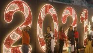 People pose for a picture next to an installation at a mall on New Year's Eve, amid the spread of the coronavirus disease (COVID-19) in Mumbai, India, December 31, 2020. REUTERS/Francis Mascarenhas
