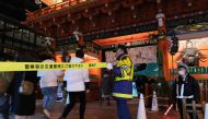 Security guards stand in front of the main gate of Kanda Myojin Shrine for New Year prayers in Tokyo on January 1, 2021. / AFP / Kazuhiro NOGI
