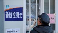 A medical worker in protective suit collects a swab from a man for nucleic acid testing at a hospital following new cases of the coronavirus disease (COVID-19) in Shenyang, Liaoning province, China December 31, 2020. cnsphoto via REUTERS