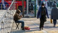 An Iranian woman wearing a protective mask amid the Covid-19 pandemic, walks past a street musician in the capital Tehran, on December 30, 2020. AFP / Atta Kenare 