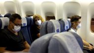 FILE PHOTO: Passengers wearing masks sit on an Air China flight from Sydney to Beijing before takeoff, in Sydney, Australia January 24, 2020. REUTERS/Thomas Peter

